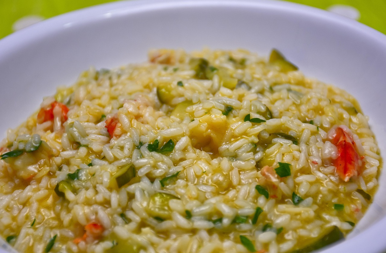 Risotto alla milanese cremoso con zafferano, servito in un piatto decorato.