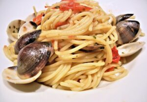 Spaghetti alle vongole serviti in un piatto, con vongole fresche e prezzemolo.